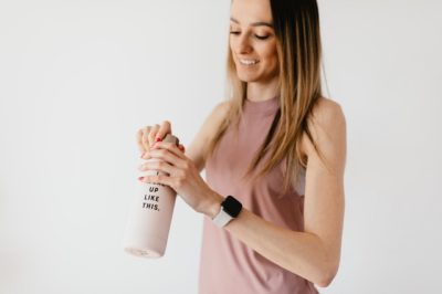 A young woman in workout clothes wears a smart watch on her wrist that measures heart rate variability