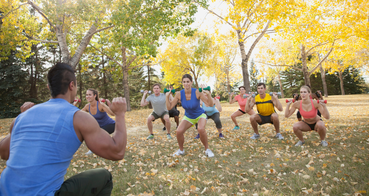 Coach leading fitness class in squats